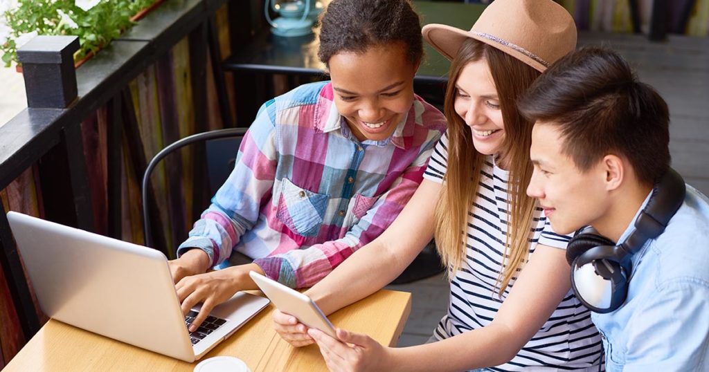 Gen Z kids looking at computer and tablet