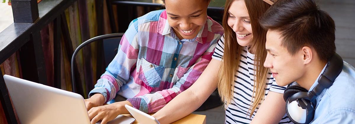 Gen Z kids looking at computer and tablet