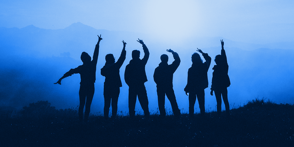 Six people silhouetted, hands raised