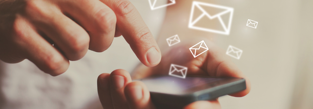 Hands holding a cellphone with icons of emails (envelopes).