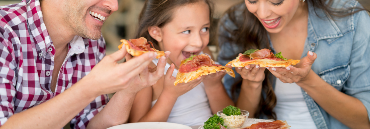 A man, child, and woman (a family) eat pizza together.