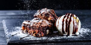 Brownie with ice cream and chocolate sauce representing a restaurant dessert used as an incentive to increase Sunday visits.