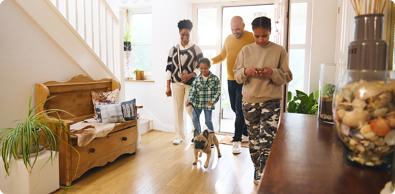 Family walking into their home with their dog
